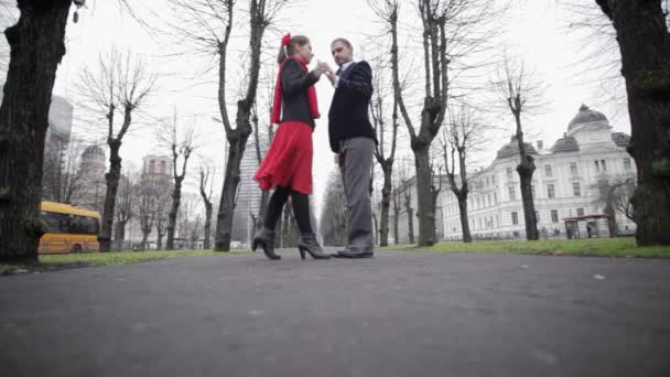 Férfi és nő tánc tangó télen üres utcán meztelen fákkal körülvett - Felvétel, videó