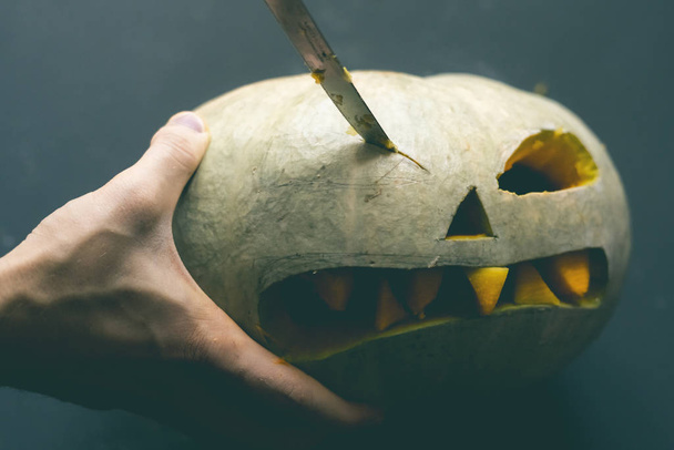 fazendo uma abóbora jack o lanterna com dentes esculpidos para o conceito halloween d
 - Foto, Imagem