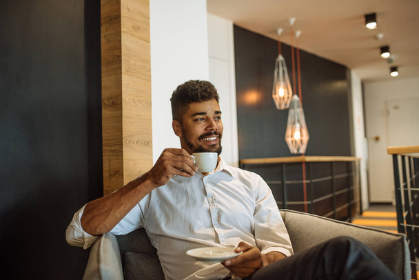 Portrait of a smiling young business man enjoying drinking coffee. - Foto, Imagen