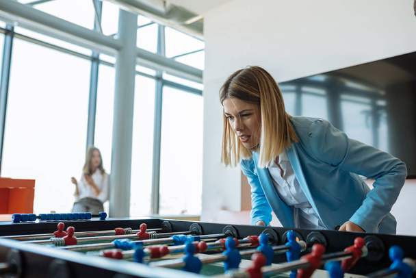 Portrait of a businesswoman playing table football. - Photo, image