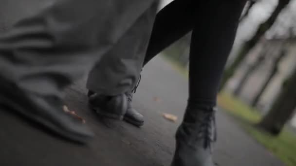 Mans és womans láb fekete bőr cipő mozog a tánc a beton út - Felvétel, videó
