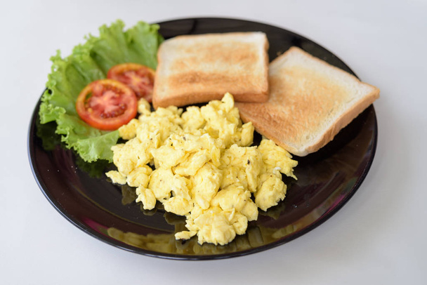 Deliciosos huevos revueltos con tostadas en mesa blanca
 - Foto, imagen