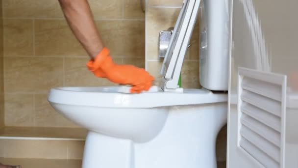 Käsi mies yllään oranssi kumi käsineet käytetään muuntaa kiillotus WC
. - Materiaali, video
