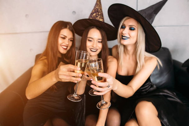 Young people posing in Halloween hats and with champagne - Valokuva, kuva