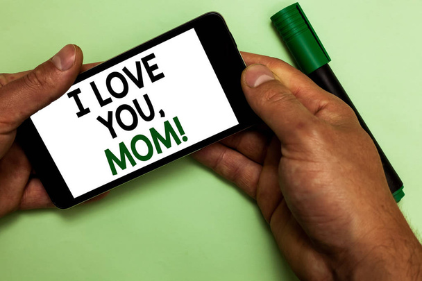 私は愛あなたのお母さんを示すメモを書きます。事業写真展示愛するメッセージ感情愛情暖かい宣言人間の手のテキスト タッチ緑のマーカーで iphone を保持します。. - 写真・画像
