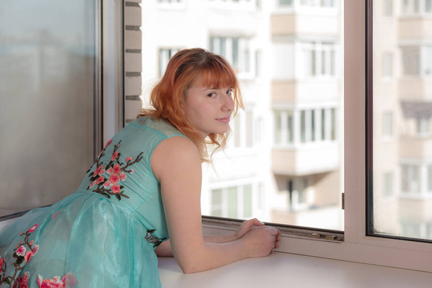 az ablak a vörös hajú lány portréja - Fotó, kép