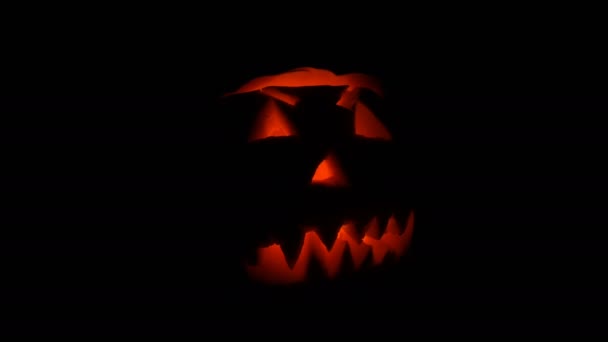 Světélkující grimasa vyřezal na Halloween dýně na den všech svatých ve tmě - Záběry, video