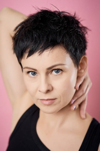 isolated woman in glasses and short hair posing on a pink background - Valokuva, kuva