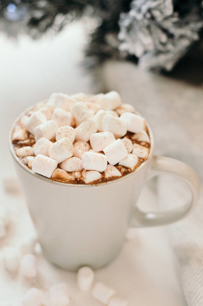 Hot cocoa with marshmallow, cinnamon, warm cozy light plaid and Christmas tree branches on white table. - Φωτογραφία, εικόνα