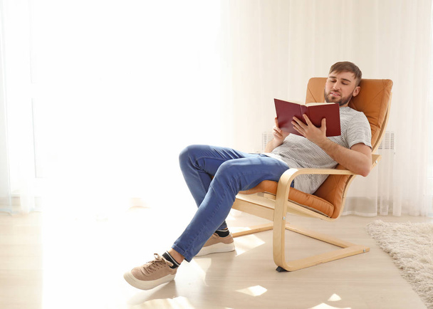 Young man reading book at home - Foto, Imagen