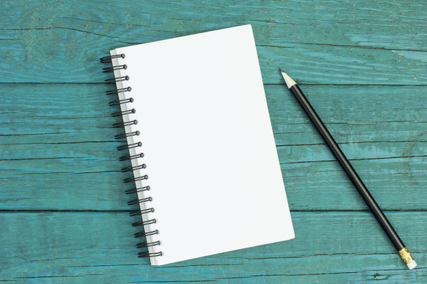 Notepad and pencil on blue wooden desk - Zdjęcie, obraz