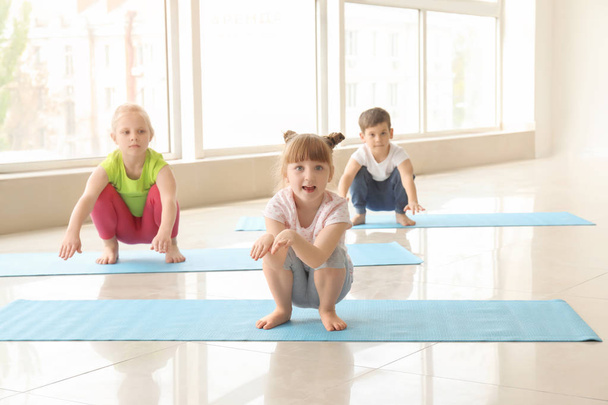 Little children practicing yoga indoors - Foto, Imagen