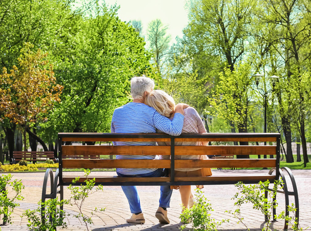 Mature couple resting in park on spring day - Fotó, kép