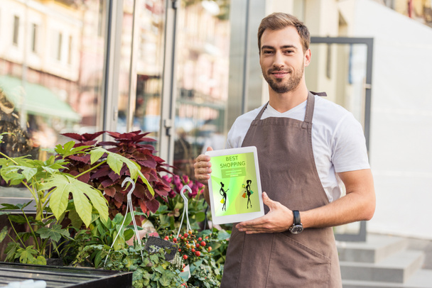 handsome florist holding tablet with best shopping appliance near flower shop - Photo, Image