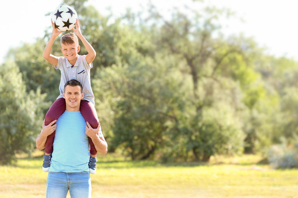 Niño y su papá con pelota de fútbol al aire libre
 - Foto, Imagen