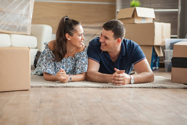 Wife laughing after the joke that her husband told in their new flat - 写真・画像