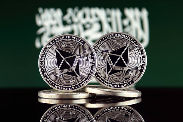 Versión física de Ethereum (ETH) y Saudi Arabia Flag. Imagen conceptual para inversores en criptomoneda, tecnología Blockchain, contratos inteligentes, fichas personales y oferta inicial de monedas
. - Foto, imagen