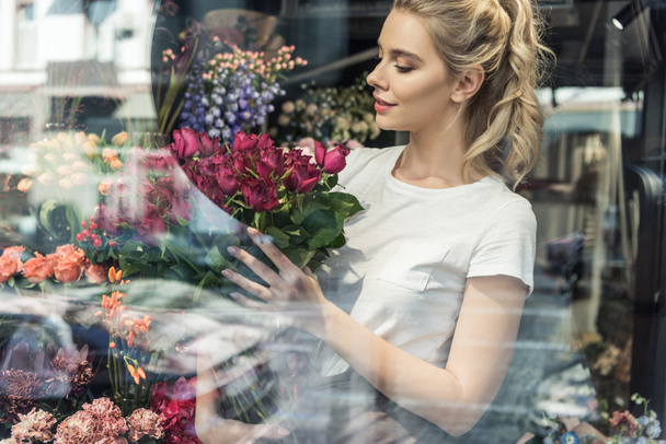 näkymä ikkunan läpi houkutteleva kukkakauppa tilalla kimppu viininpunainen ruusut kukkakauppa
 - Valokuva, kuva