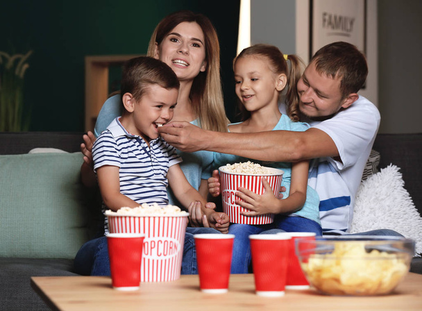 Pattogatott kukoricát eszik este Tv nézés közben boldog család - Fotó, kép