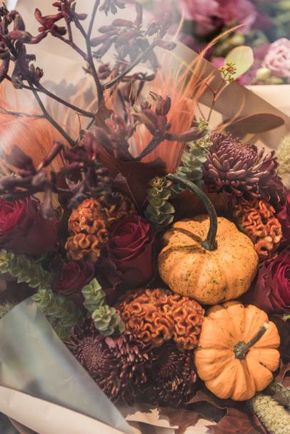 beautiful decorative autumnal bouquet with small pumpkins at flower shop - Photo, image