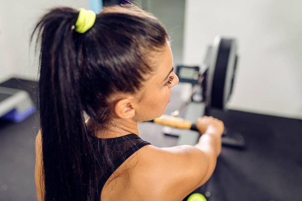 Girl working out on rowing machine - Photo, Image
