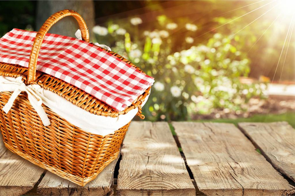 picnic wicker basket on wooden table  - Фото, изображение