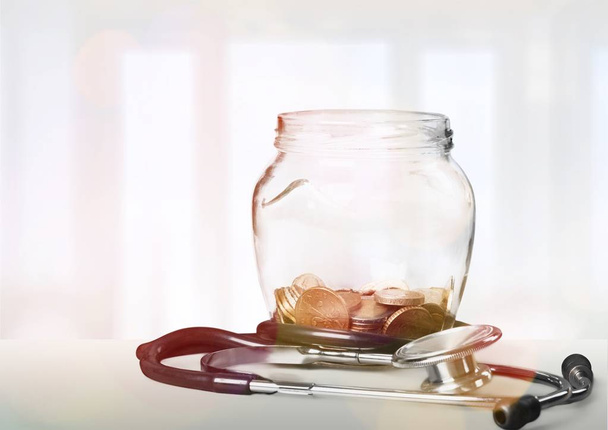 Money Jar with coins and stethoscope, close-up view - Foto, Imagem