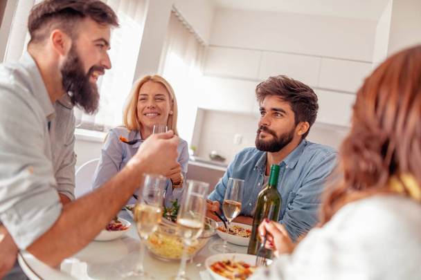 Група друзів їдять здорову їжу вдома і чудово проводять час разом
 - Фото, зображення