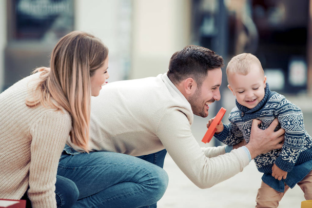 Продажа, потребительство и понятие людей - счастливая семья с маленьким ребенком в городе
. - Фото, изображение