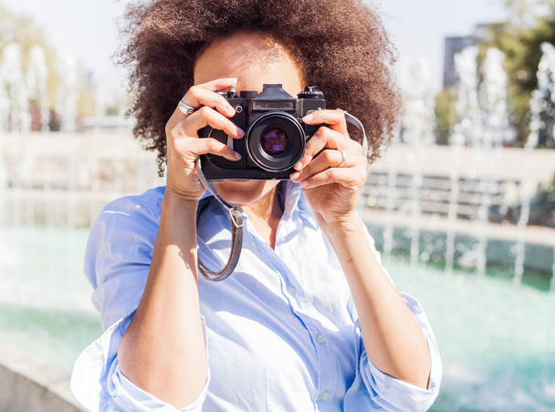 African american woman with retro camera, female photographer taking photo with vintage camera at summer day - Photo, Image