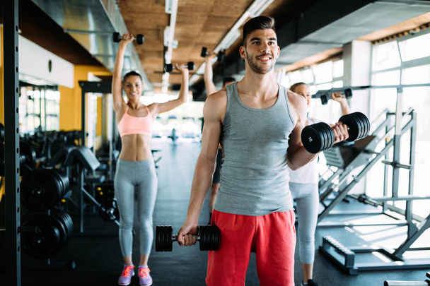 Muscular bodybuilder workout in gym doing biceps exercises with bar - Foto, Imagem