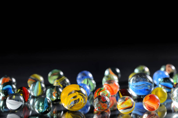 Bolas de vidro de mármore diferentes no fundo preto
 - Foto, Imagem
