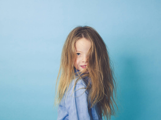 portrait of happy girl in casual clothes looking at camera on pastel blue background    - Foto, afbeelding