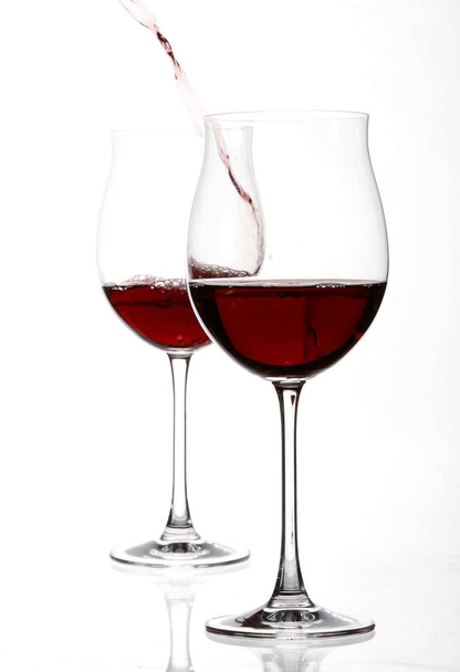 red wine pouring in wineglass isolated on white background, close-up  - Photo, Image