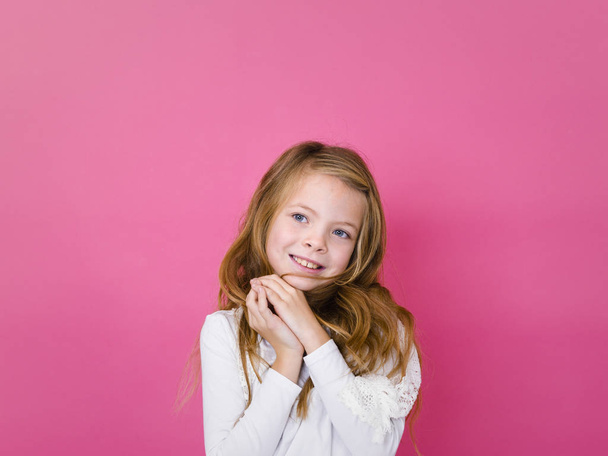 portrait of happy girl in casual clothes looking aside and smiling on pink background    - Foto, Imagen
