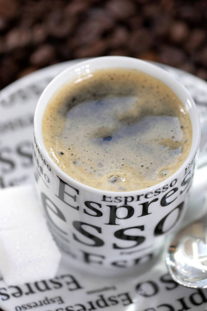 эспрессо в декоративной чашке на коричневом размытом фоне
  - Фото, изображение