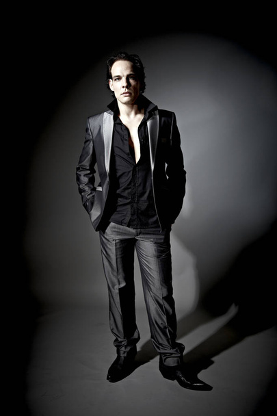 handsome businessman model in suit posing on dark studio background  - Fotó, kép