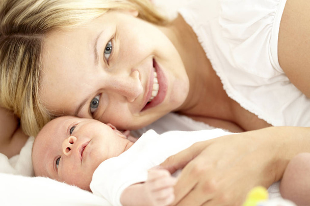 glückliche junge Frau entspannt mit ihrer sieben Monate alten Tochter - Foto, Bild