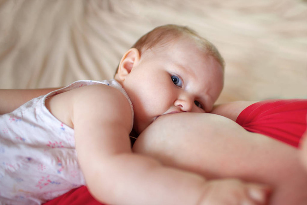 Mom breast feeding baby girl - Photo, image