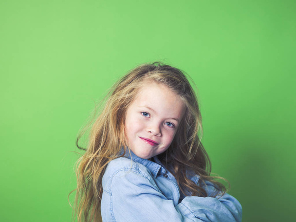portrait of happy girl in casual clothes looking at camera on green background    - Foto, immagini