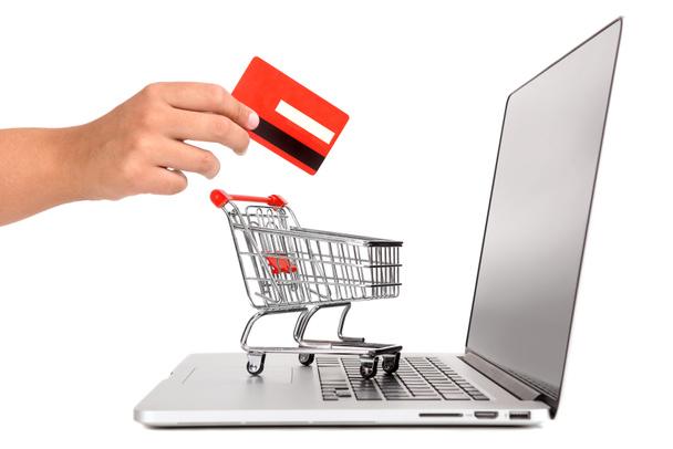 Kannettava tietokone pieni ostoskori ja käsi luottokortilla eristetty valkoinen
 - Valokuva, kuva
