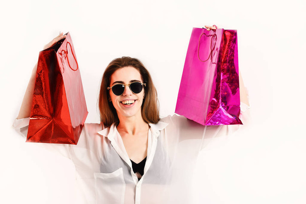 Woman with packages. Girl in sunglasses with smiling face - Foto, immagini