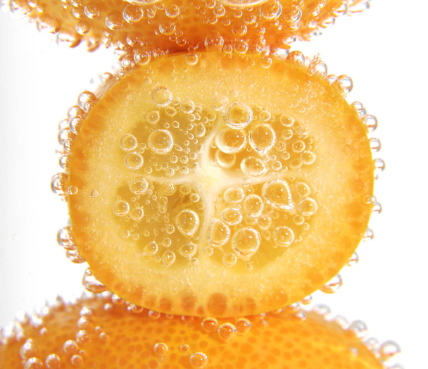 kumquat chinese fruits with air bubbles in water on white background, close-up  - 写真・画像