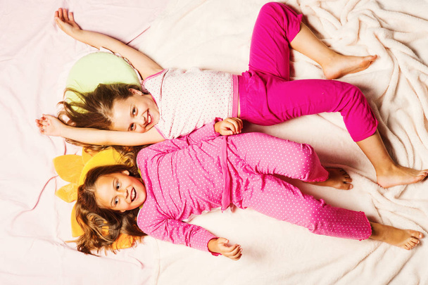Les enfants avec des visages souriants reposent sur fond rose - Photo, image