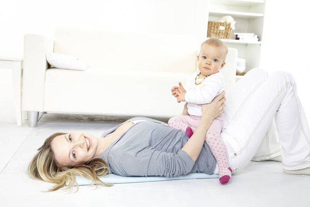 boldog fiatal nő pihentető otthon hét hónapos lánya - Fotó, kép