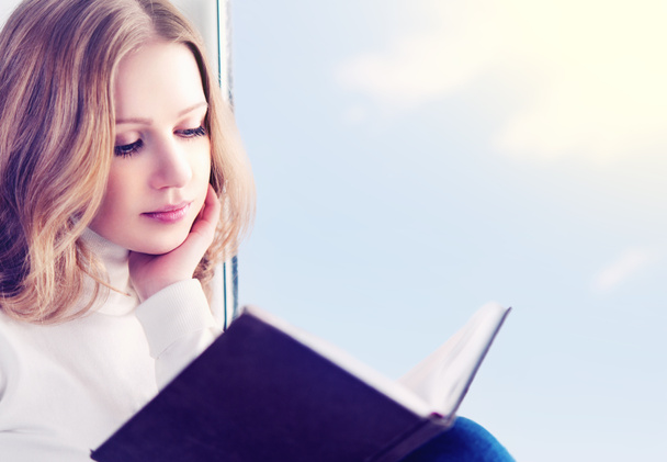 belle jeune femme lisant un livre assis à une fenêtre
 - Photo, image