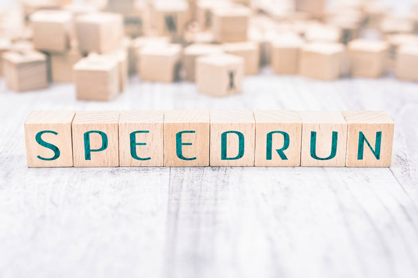 Η λέξη Speedrun σχηματίζεται από ξύλινα μπλοκ σε έναν λευκό πίνακα - Φωτογραφία, εικόνα