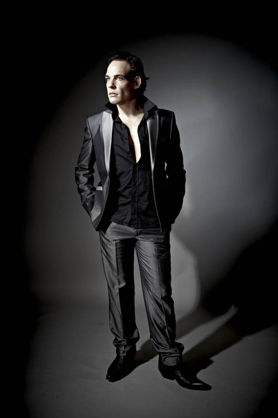 handsome businessman model in suit posing on dark studio background  - Foto, afbeelding