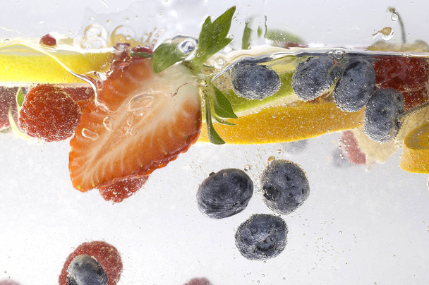  фрукты и ягоды под водой на белом фоне, крупным планом
  - Фото, изображение
