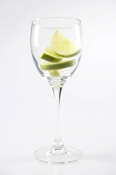 wineglass with lime slices isolated on white background, close-up  - 写真・画像